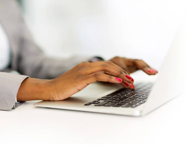 hands typing at a laptop computer
